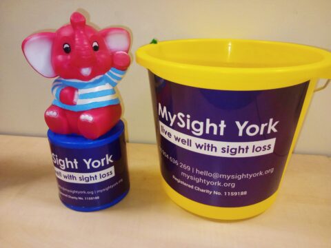 A MySight York Pink Elephant tin and a yellow MySight York collection bucket