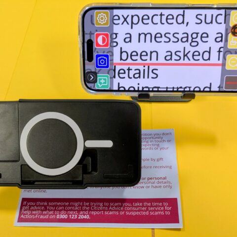 black optaro magnifier with image of text it is magnifying on iPhone screen