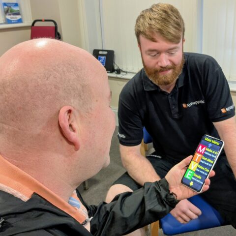 Two men looking at Synapptic mobile phone