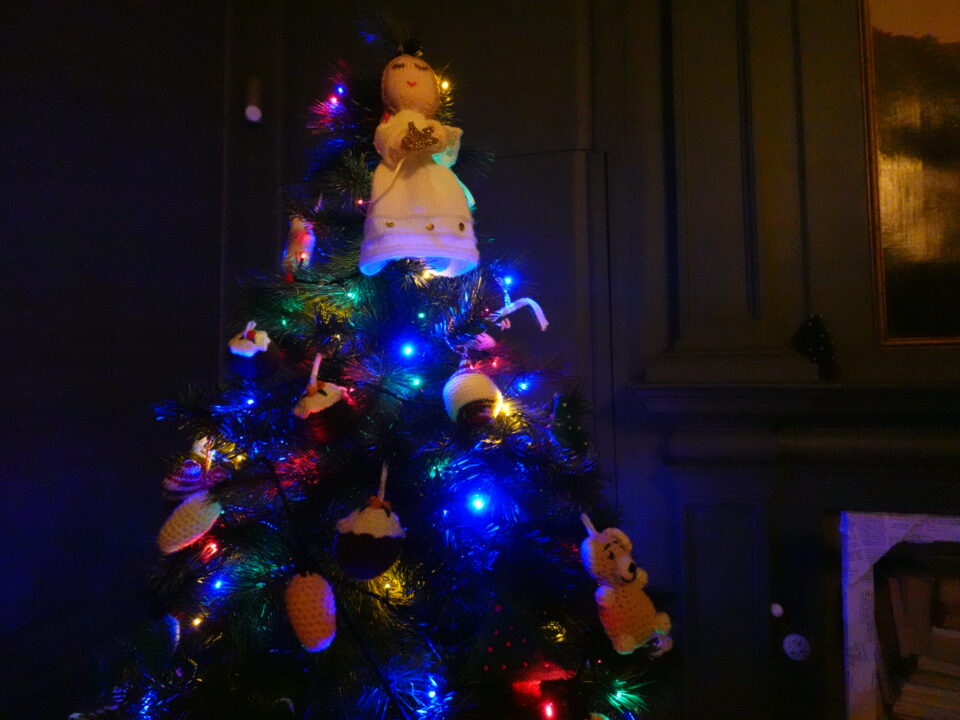 An angel made by a MySight York member, at the top of a Christmas tree, surrounded by decorations also made by MySight York members, displayed at Treasurer's House.